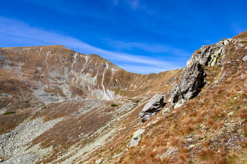 Scenic view on the ridges of Haemerkogel in the Lower Tauern mountain range, Styria, Austria, Europe. Sunny autumn day in Seckau Alps. Scenic hiking trail to Seckauer Zinken on dry, bare terrain. Rock