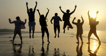 Big group of seven happy friends is having fun and jumping on beach during sunset time at Kuakata sea beach, Bangladesh - obrazy, fototapety, plakaty