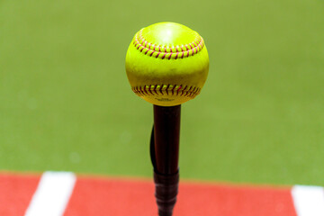 Closeup shot of a softball on the stick on the green lane