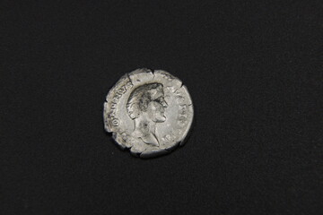 Silver ancient Roman coin on a black background
