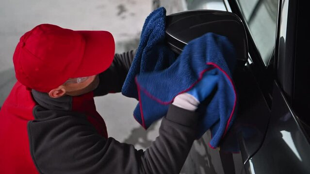 Professional Caucasian Car Detailing Worker Cleaning Side Mirror Using Soft Cloth