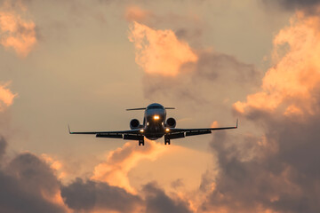 Dark silhouette of an small airplane at sunset approach in the airport of a beautiful beautiful sky.