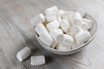 Fototapeta na wymiar White marshmallows in a porcelain bowl on the table