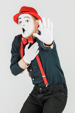 Clown with red suspenders and red hat on white background