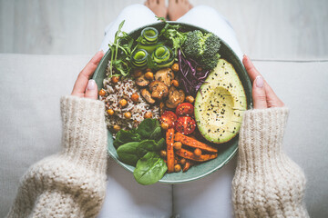 Woman eating vegan or vegetarian meal. Buddha vegan bowl with fresh vegetables. Vegan food plate....