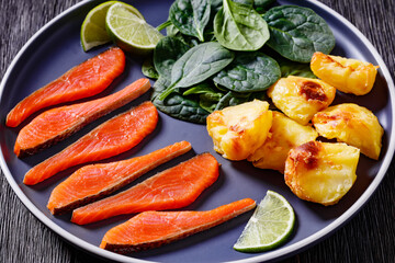 salmon slices with spinach leaves, roast potatoes
