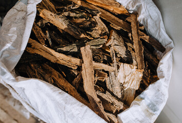 Pieces of peeled acacia tree bark, spruce lies in a bag close-up.