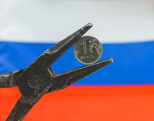 one Russian ruble coin in old pliers, the concept of the crisis in Russia and sanctions against the...