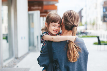 Woman carrying her cute little daughter