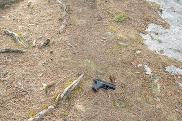 Abandoned pistol in the forest. view from above