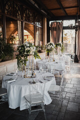 Table decoration for a special occasion - white plates and green plants. Eco/nature friendly decoration. 