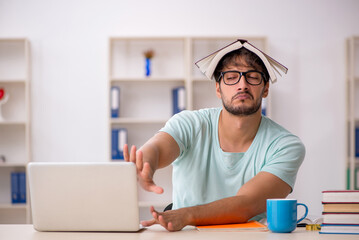 Young male student preparing for exams in the classroom