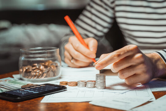 Young Focused Man Paying Bills Online On Computer Laptop Paper Document On Table Worried About High Bill Invoice, Overdue Debt, Expenses, Expenditures Household Finances Taxes Payment On Calculator