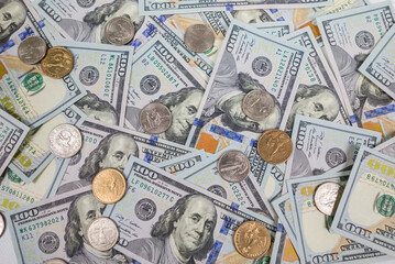 Pile of dollar bills and coins as a background.