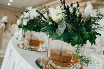 Table decoration for a special occasion - white plates and green plants. Eco/nature friendly decoration. 