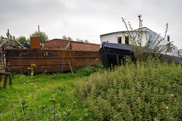 Fototapeta na wymiar Two canal boats dry docked in a Hertfordshire field, one nearly completed and one ready for work