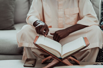 African Muslim couple at home in Ramadan reading Quran holly Islam book.
