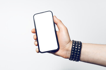 Close-up of male hand wearing bracelet, holding smartphone with blank screen.
