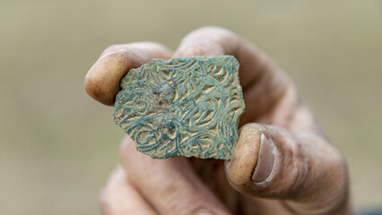 Closeup shot of a fragmented Viking Age brooch in bronze with gold inlays in Denmark