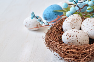Easter eggs in a nest on a light background. Happy easter concept with copy space