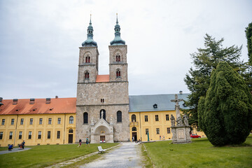 Fototapeta na wymiar Tepla, Czech Republic, 7 August 2021: Premonstratensian Abbey and monastery, Romanesque church of the Annunciation with towers, gothic arched portal with stone carved statues of saints at summer day