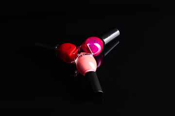 Colorful nail polish bottles on black table.