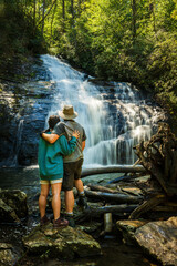 Hiking couple hugs at the base of Helton Creek Water Falls