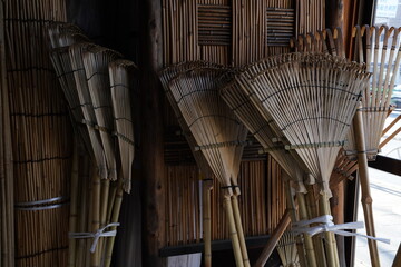 倉に積んである竹ほうきの束、日本の清掃道具