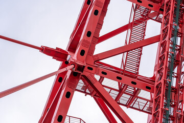 Close-up of fragment of red cable-stayed bridge pylon in place where metal cables are fastened....