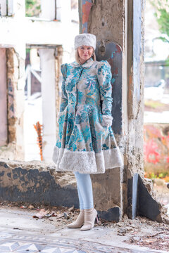 A beautiful woman in a winter coat and winter hat (Ushanka). A beautiful woman in an abandoned castle.