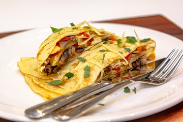 Russian pancakes with stuffing and sprinkled with grated cheese