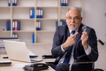 Old male employee in wheel-chair in happy idea concept