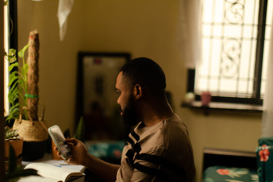 Portrait of a black gardener scrolling on instagram at home  