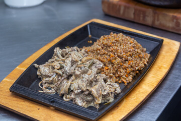 Beef Stroganoff - a traditional Russian dish with buckwheat porridge is on a plate