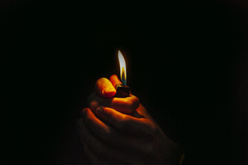Closeup shot of a lighter in a person's hands - obrazy, fototapety, plakaty
