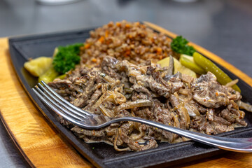 Beef Stroganoff - a traditional Russian dish with buckwheat porridge is on a plate