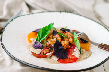 Mix tomatoes with capers and tuna. Tomato menu in a restaurant.