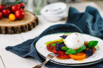 Buffalo burrata cheese served with fresh raw tomatoes and basil leaves