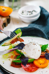 Buffalo burrata cheese served with fresh raw tomatoes and basil leaves