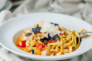 pasta with chicken, bacon, cherry tomatoes and zucchini with light cream tomato sauce