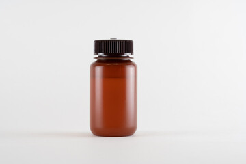 Brown amber medicine glass bottle of essential oil isolated on white background