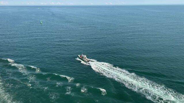A pilot boat escorting a cruise ship out of Port Canaveral, FL.