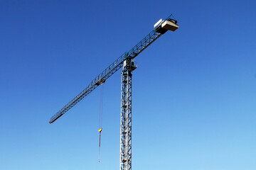 Naklejka premium construction crane on the background of a bright blue sky