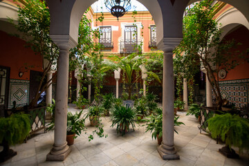 Andalusian style, patio with green plants and arches, old town Seville, Spain