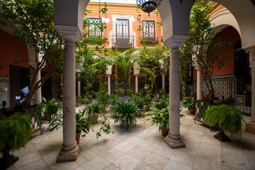 Andalusian style, patio with green plants and arches, old town Seville, Spain