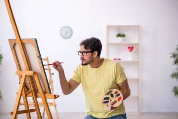 Young man enjoying painting at home