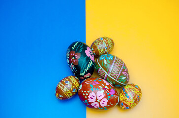 wood painted colorfull easter eggs on blue-yellow background