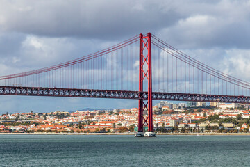 Fototapeta premium The 25 de Abril Bridge, 25th of April Bridge, a red suspension bridge over the Tagus river, Lisbon, Portugal