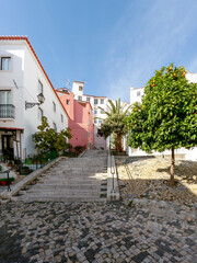 Street of the Alfama district, the oldest neighborhood of Lisbon with traditional houses and paved road, Portugal, Europe