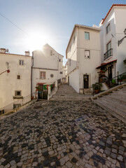 Street of the Alfama district, the oldest neighborhood of Lisbon with traditional houses and paved road, Portugal, Europe